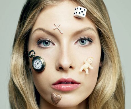 Image: Young woman with icons of time, babies, gambling and love on her face